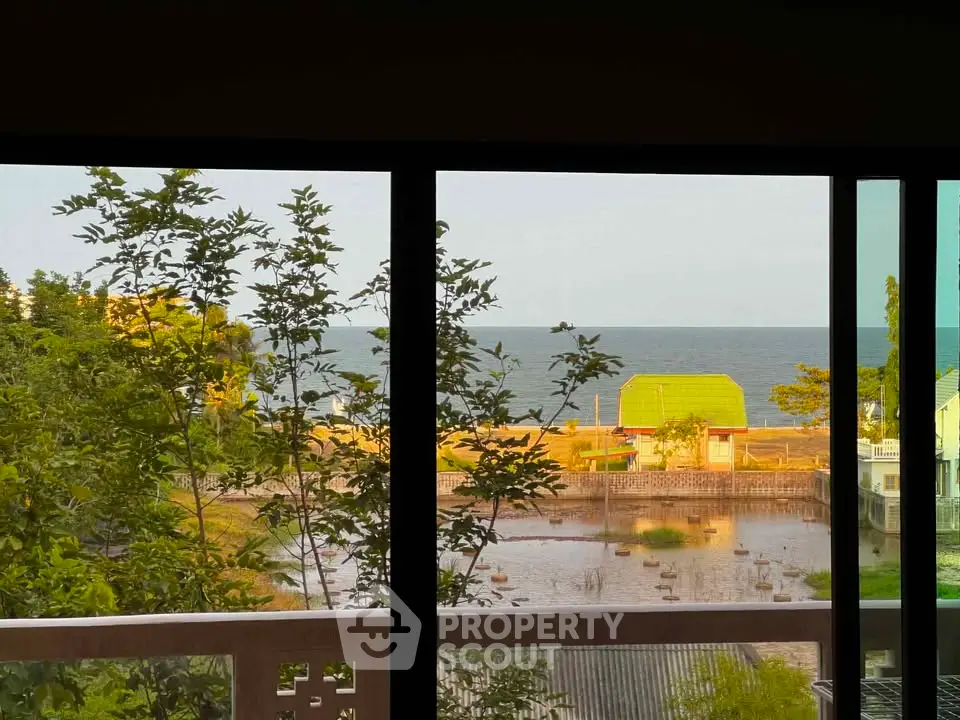 Stunning ocean view from a balcony with lush greenery and serene surroundings.