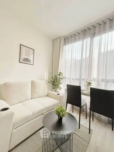 Bright and modern living room with cozy seating and dining area, featuring large windows and stylish decor.