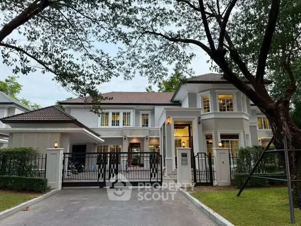 Stunning two-story house with elegant architecture and lush greenery, perfect for family living.
