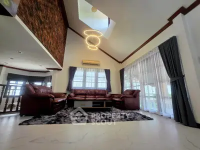 Spacious living room with high ceiling and modern lighting in elegant home.