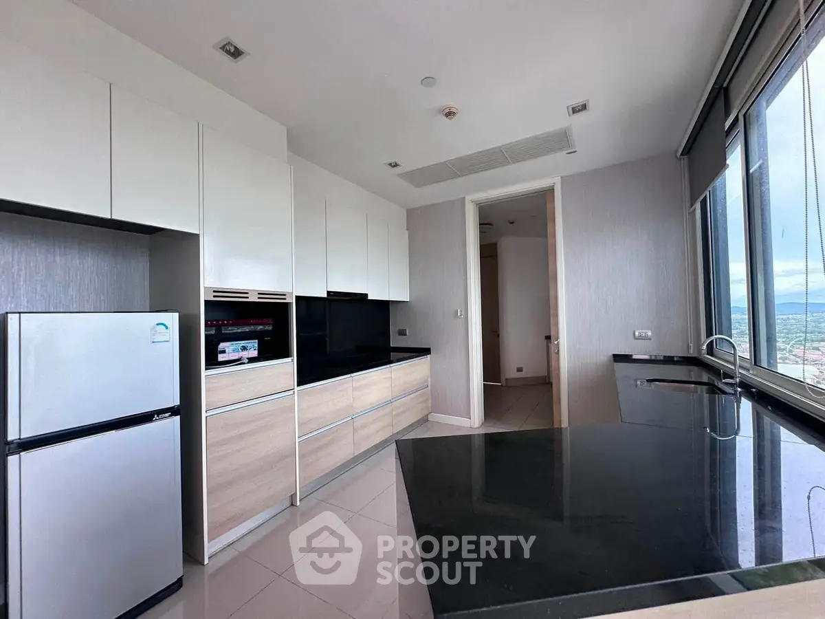 Modern kitchen with sleek cabinetry and panoramic window view