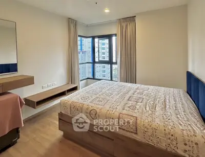 Spacious bedroom with large windows and modern decor in urban apartment