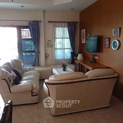 Cozy living room with elegant leather sofas and wall-mounted TV, perfect for relaxation and entertainment.