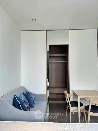 Modern apartment interior with cozy sofa, dining table, and built-in wardrobe.