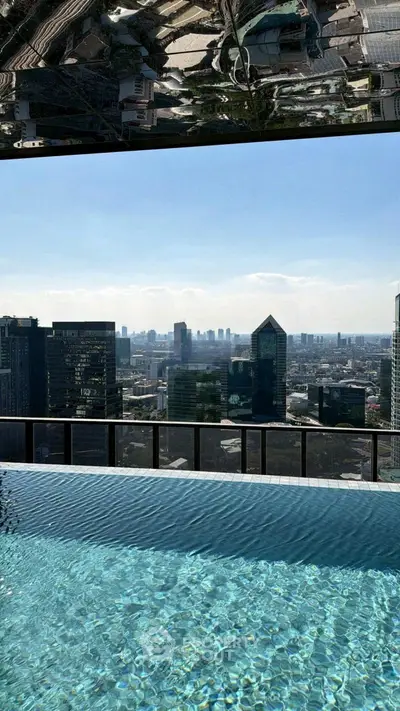 Luxurious rooftop pool with stunning city skyline view in modern high-rise building.