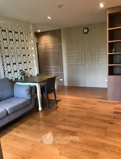 Spacious living room with modern decor and wooden flooring in a stylish apartment.