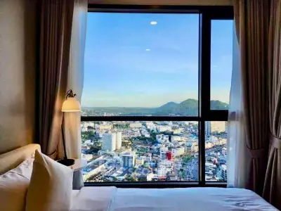 Stunning bedroom view with panoramic cityscape and mountain backdrop, perfect for urban living enthusiasts.