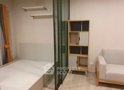 Modern minimalist living space with glass partition and stylish shelving unit.