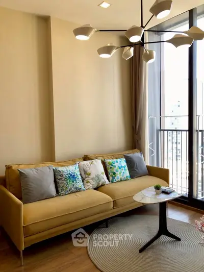 Stylish living room with modern chandelier and cozy sofa near balcony view.