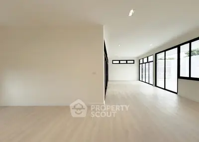 Spacious modern interior with large windows and light wood flooring