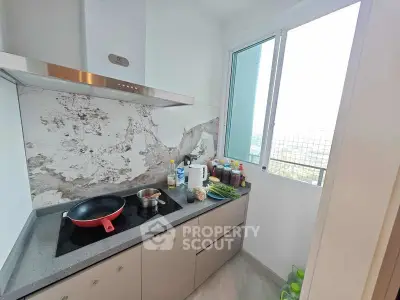 Modern kitchen with sleek cabinetry and large window offering natural light and scenic views.