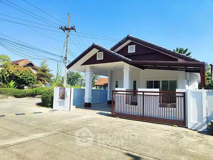 Charming single-story house with spacious driveway and lush greenery, perfect for serene living.