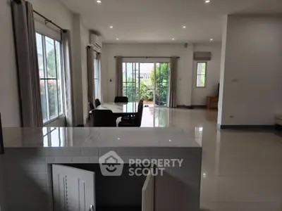Spacious open-plan living room with large windows and garden view