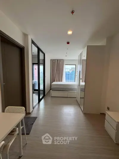 Modern studio apartment with sleek design and city view, featuring a cozy bedroom and dining area.