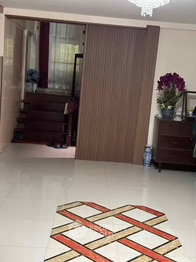 Spacious living area with modern decor and elegant staircase