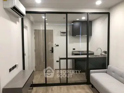 Modern studio apartment with glass partition and sleek kitchen design