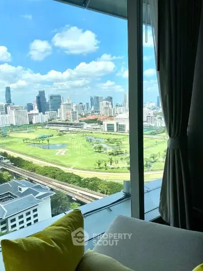 Stunning cityscape view from a high-rise apartment with lush green golf course below.