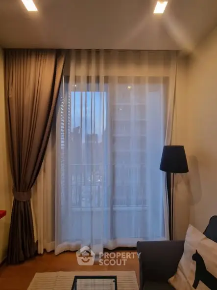 Cozy living room with elegant curtains and modern lighting, perfect for relaxation.
