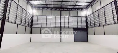 Spacious industrial warehouse with high ceilings and large roller door access.