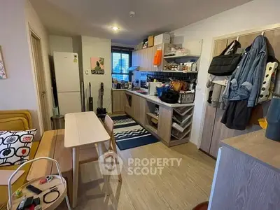Cozy kitchen with modern appliances and dining area in a compact apartment setting.