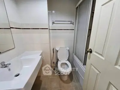 Compact bathroom with modern fixtures and a bathtub in a cozy real estate unit.