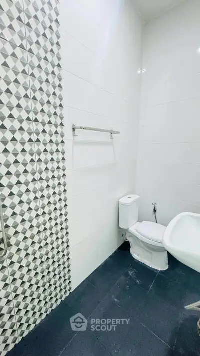 Modern bathroom with geometric tile design and sleek fixtures