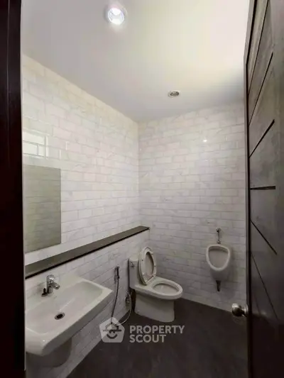 Modern bathroom with sleek white tiles and contemporary fixtures.