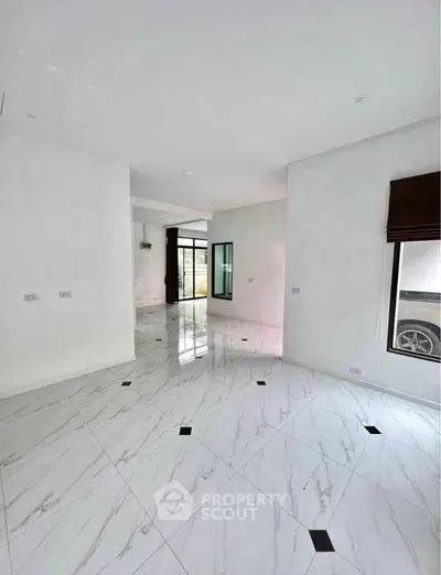 Spacious modern interior with elegant marble flooring and large windows.
