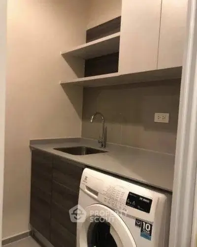 Modern laundry room with washing machine and sleek cabinetry