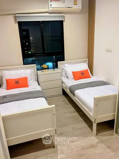 Modern twin bedroom with stylish decor and city view, perfect for urban living.