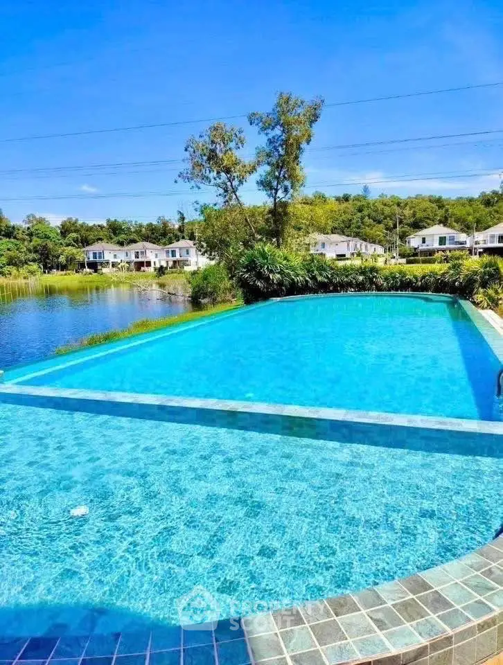Stunning pool with serene lake view in a tranquil residential area.