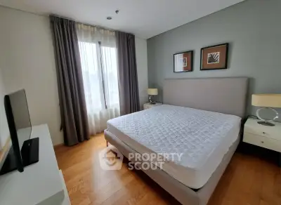Spacious bedroom with modern decor and large window for natural light