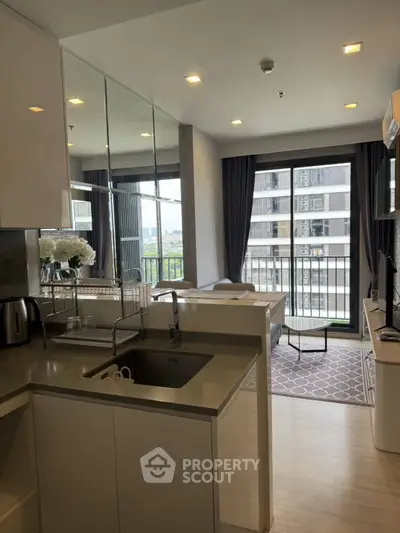 Modern open-layout kitchen with sleek design and balcony view in urban apartment