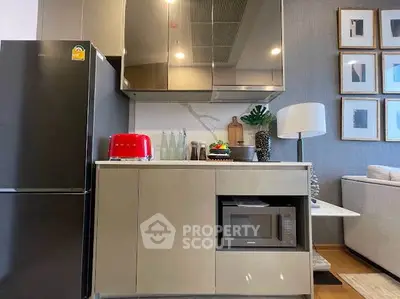 Modern kitchen with sleek cabinets, red toaster, and microwave in stylish apartment.