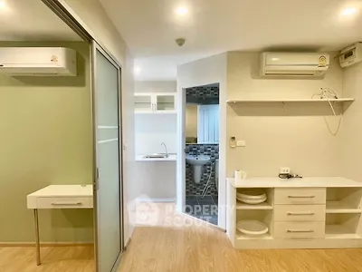 Modern studio apartment with compact kitchen and bathroom, featuring air conditioning and sleek storage solutions.