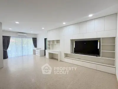 Spacious modern living room with built-in entertainment center and large windows.