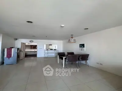 Spacious open-plan living area with modern dining set and minimalist decor.