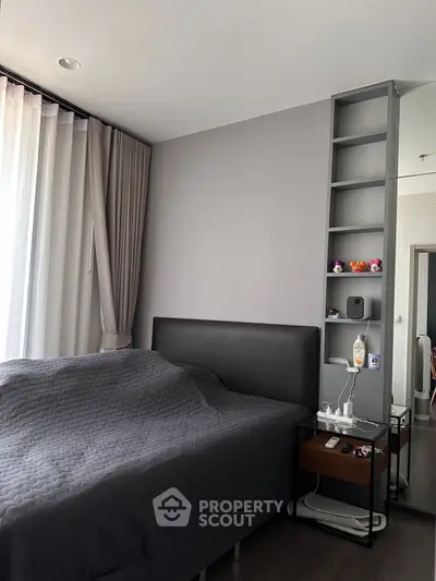Modern bedroom with sleek design, featuring a cozy bed and stylish shelving unit.
