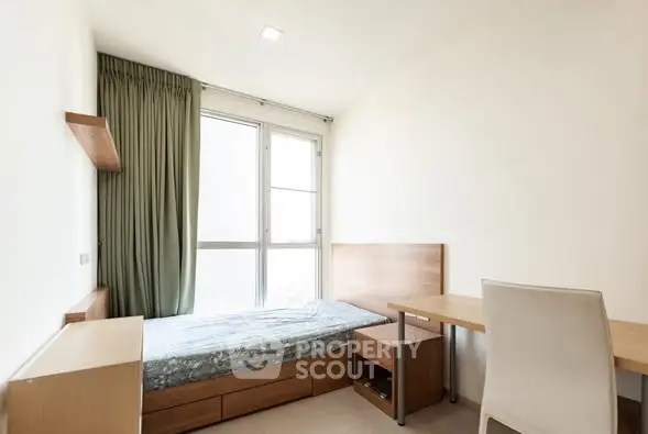 Cozy minimalist bedroom with natural light and modern furnishings, perfect for urban living.