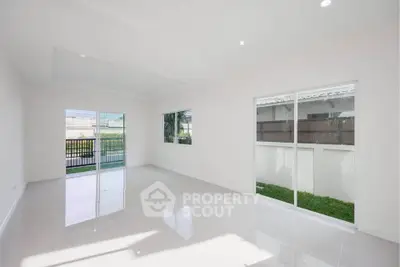 Spacious modern living room with large windows and garden view, perfect for natural light lovers.