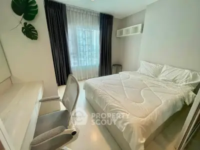 Modern bedroom with cozy bed, study desk, and large window with city view.