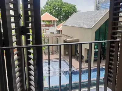 Chic urban balcony view overlooking modern pool and stylish building.