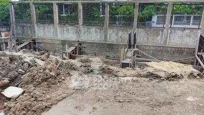 Construction site with concrete walls and dirt piles, potential for future development.
