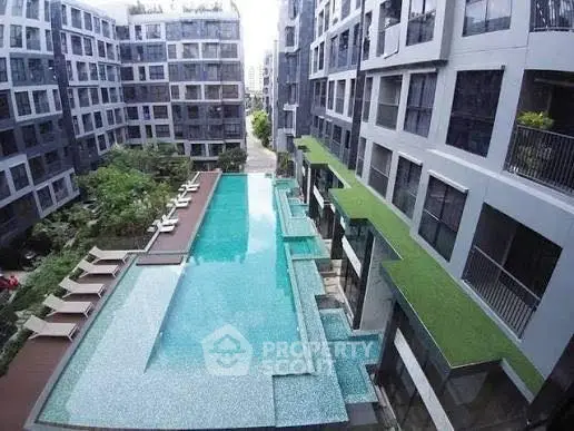 Luxurious modern apartment complex with stunning outdoor pool and lush greenery.