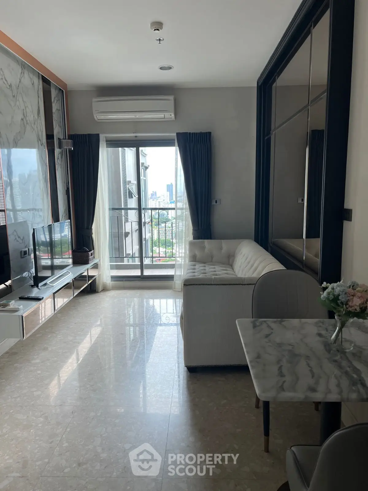 Modern living room with balcony view, featuring sleek marble floors and stylish furniture.