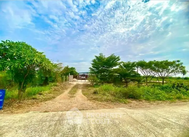 Expansive plot of land with lush greenery and clear skies, perfect for development opportunities.