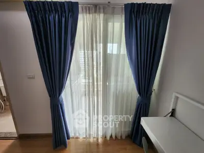 Elegant room with blue curtains and a study desk, perfect for a serene workspace.