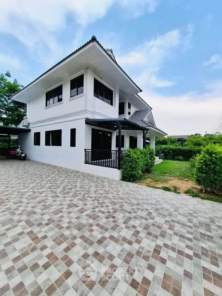 Stunning two-story white house with spacious driveway and lush greenery, perfect for family living.