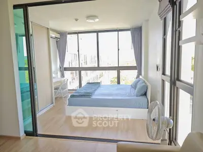 Bright and airy bedroom with large windows and modern furnishings in a stylish apartment.