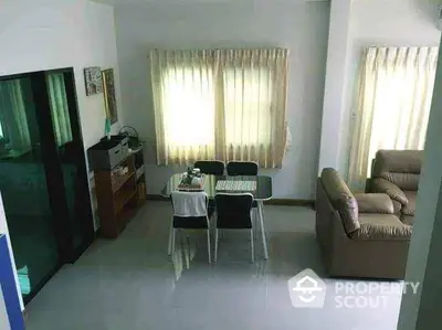 Cozy living room with dining area, featuring natural light and comfortable seating.